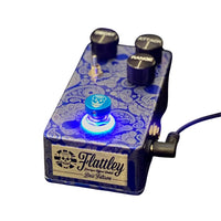 Angled front view of Flattley Bass Filtron Bass Envelope Filter Pedal with power cable attached on white background