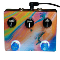 Top view of Flattley Bass Solaris Bass Fuzz with Boost Pedal attached to power cable on white background