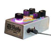 Angled front view of Flattley Nirvana Analogue Delay Pedal with power cable on white background