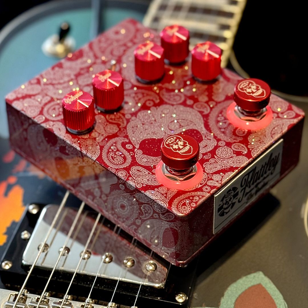 Angled view of Flattley The Outlaw Pedal on top of guitar