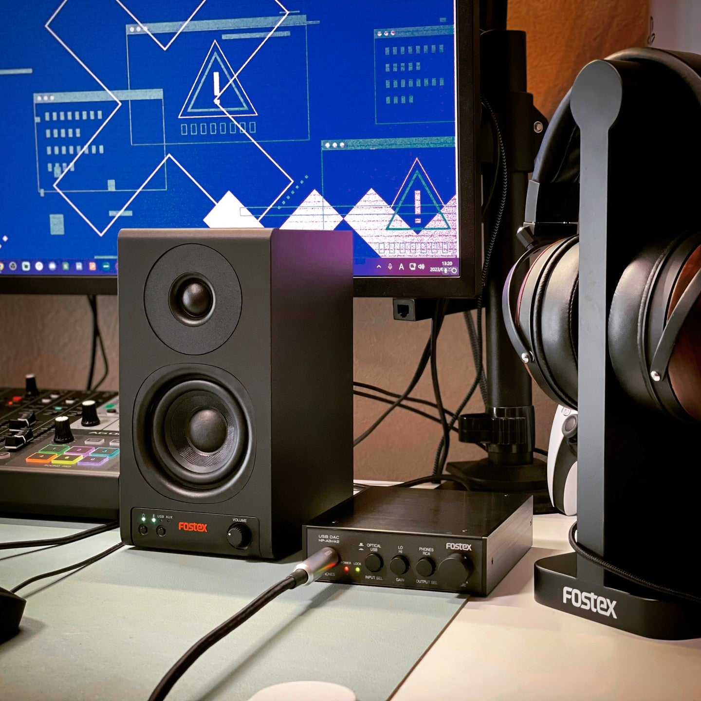 Fostex PM0.3BD 3" Active Speakers with Bluetooth and USB-DAC on top of desk beside mixer, audio interface, and headphones in studio