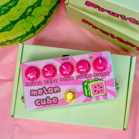 Front view of FruitFX Melon Cube Pedal on top of green box on pink surface with watermelon and more boxes around it