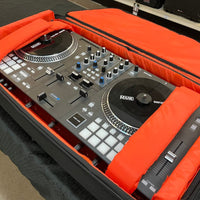 DJ controller in an orange case on a wooden surface