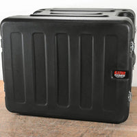 Black hard-shell case with Gator logo on a wooden surface