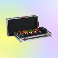 Set of guitar effect pedals in a hard-shell case on a gradient background