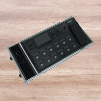 Black electronic device with buttons and display on a wooden surface