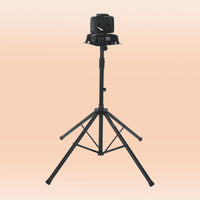 Black tripod stand with a spotlight on a beige background