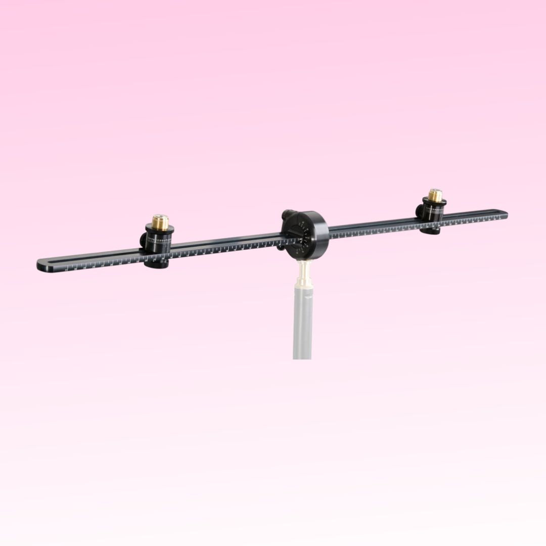 Angled front view of Grace Design SB-66 25.98" Spacebar Stereo Microphone Mounting Kit on pink background