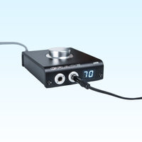 Angled front view of Grace Design m900 DAC Headphone Amplifier with cables attached on blue background