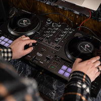DJ playing the Hercules DJControl Inpulse T7 DJ Controller on marbled surface