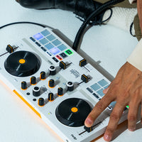 Angled front view of Hercules DJControl Mix Ultra DJ Controller being used by DJ on white surface