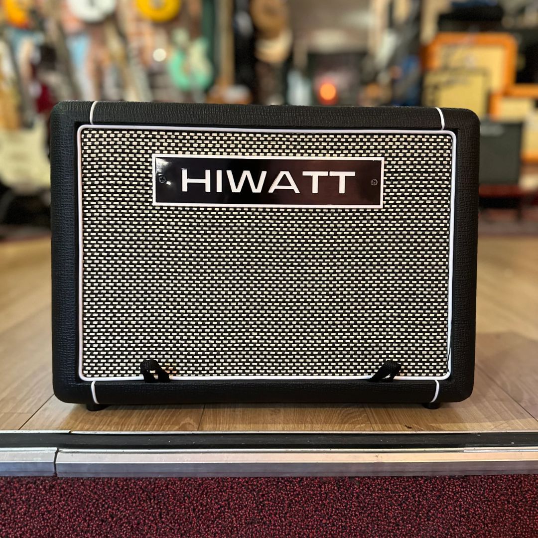 Front view of Hiwatt LEEDS AC60 Combo Guitar Amplifier on wooden surface with guitars in the background