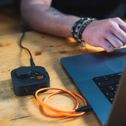 IK Multimedia ARC ON-EAR on wooden table with laptop and mixing engineer using it.
