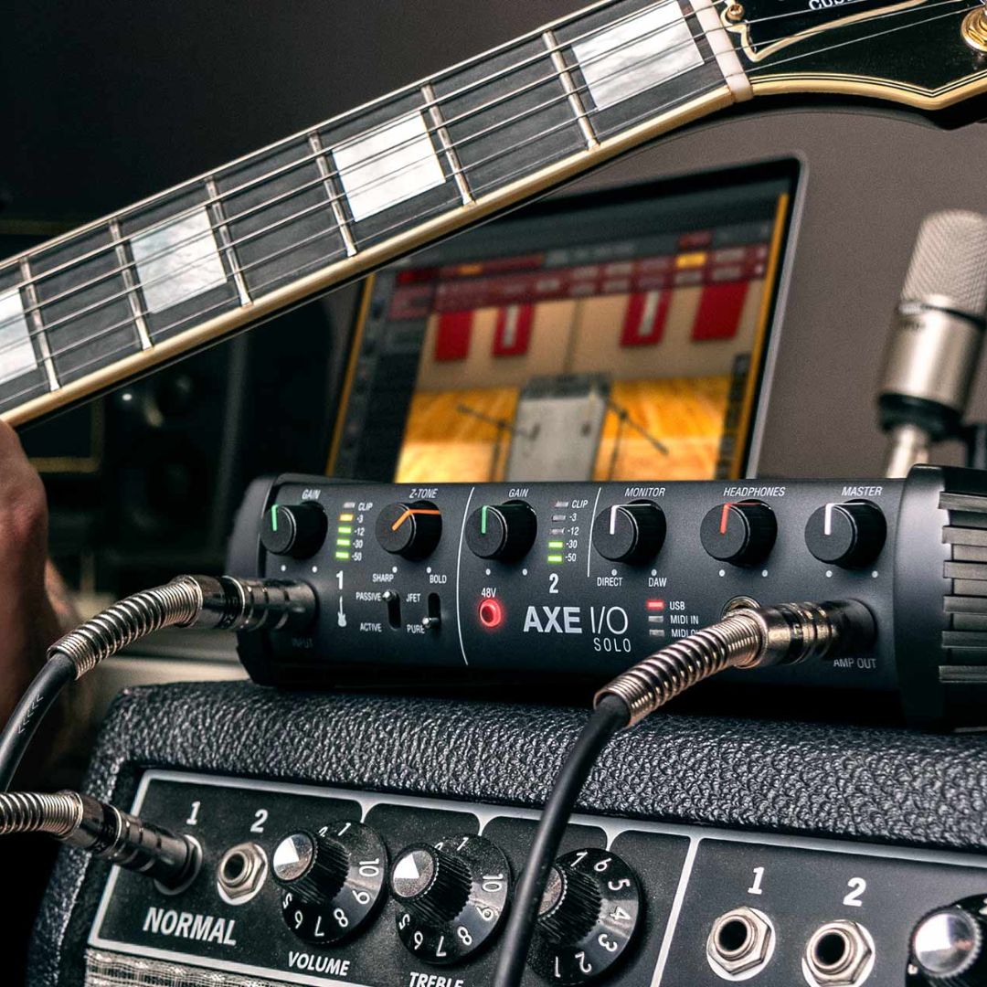 Guitar with audio interface and microphone setup on a desk