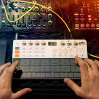 Person using a digital audio workstation with a focus on the control panel and hands.