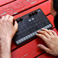 Person using a digital audio workstation on a red wooden surface