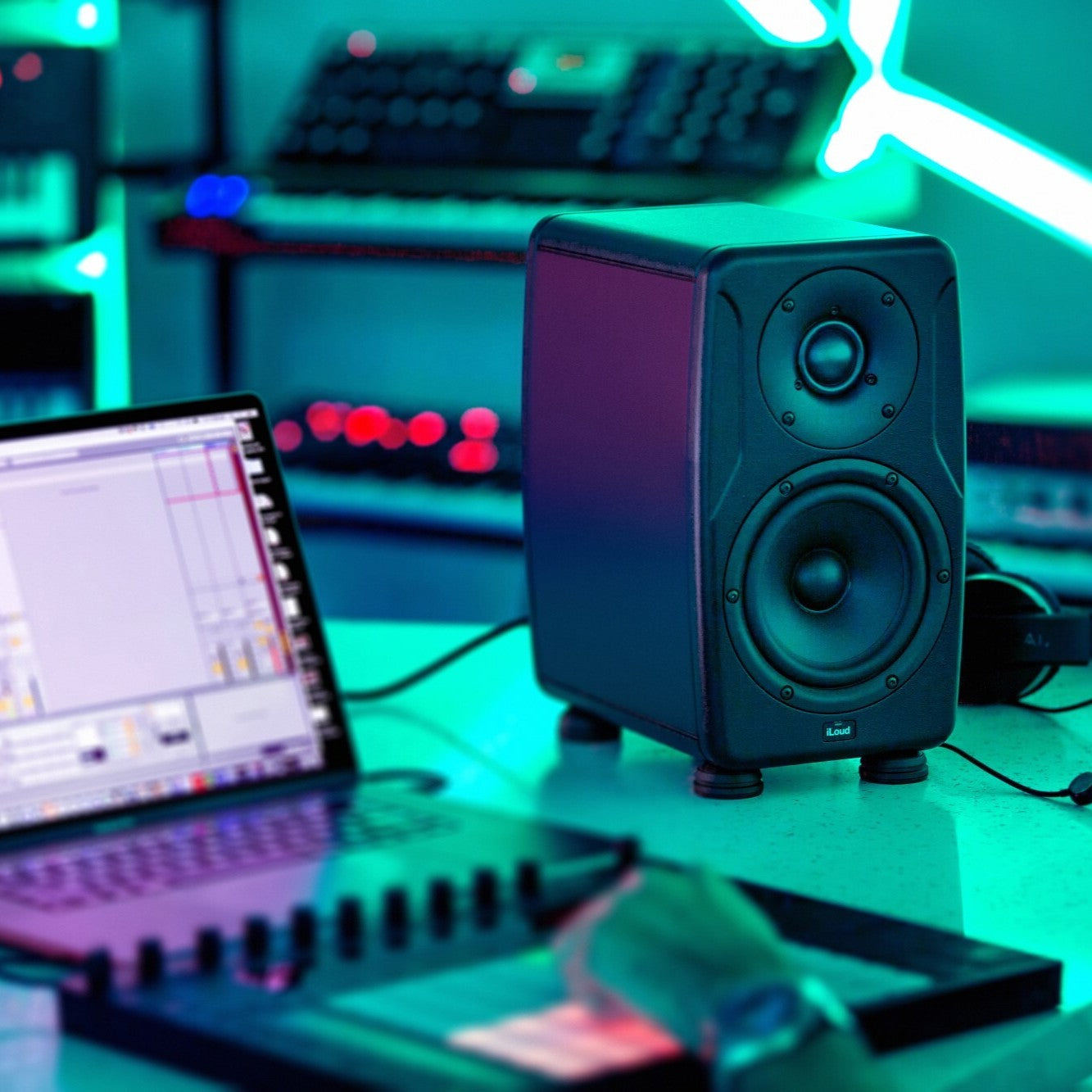 Angled view of IK Multimedia iLoud Precision 6 on studio desk with DJ using it