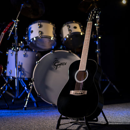Angled front view of Jay Turser JJ43 3/4 Size Acoustic Guitar Black with drum kit in background in studio