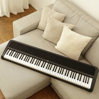 Angled top view of Korg B2 Digital Piano Black on gray couch in living room