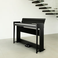 Side view of Korg C1 Air Digital Piano Black in studio with stairs in the background