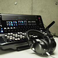 Front view of Korg FISA SUPREMA Aero Digital Accordion Buttons with headphones on white surface with concrete background