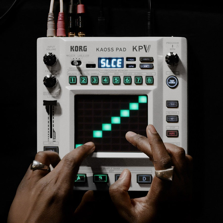 Hands playing with the Korg KAOSS Pad V Dynamic Effect / Sampler on dark desk