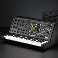 Angled view of Korg MS-20 mini Monophonic Synthesizer with another synth behind and a gray background