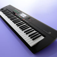 Angled view of Korg i3 Super Matte Black on purple background