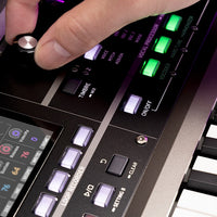 Close up view of Korg microKORG2 with hand tweaking knob