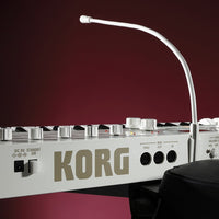 Close up angled rear view of Korg microKORG S with vocoder mic on red background
