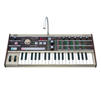 Angled front view of Korg microKORG with Vocoder microphone attached on white background