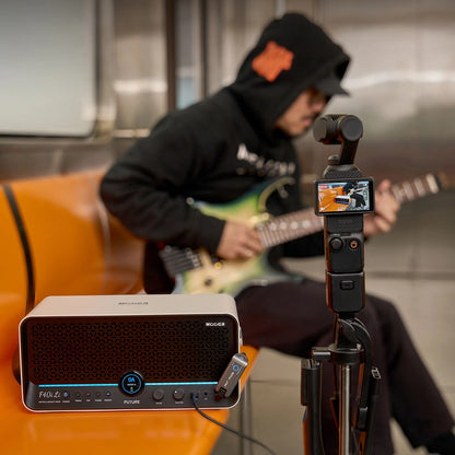 Guitarist playing through a MOOER F40i Li Snowfall White while recording himself on a train