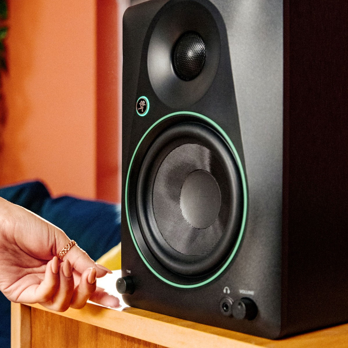 Hand turning the knob of Mackie CR8BT 8" Powered Studio Monitors with Tone Control & Bluetooth in studio