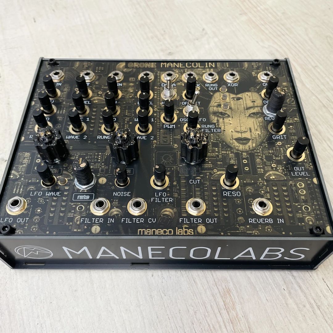 Angled front view of Maneco Labs Manecolin Table Top Synth on wooden surface