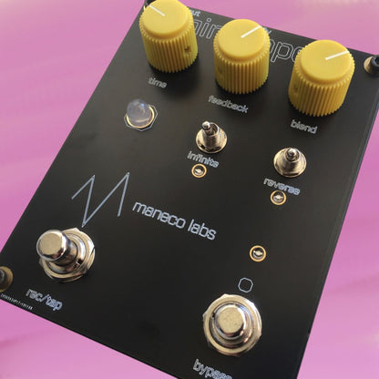 Angled view of Maneco Labs Mini Looper Pedal on pink background