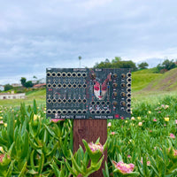 Front view of Maneco Labs Zeptomod Mega Module on stump outdoors