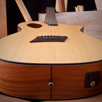 Close-up of a wooden acoustic guitar with a blurred background