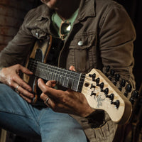 Person playing a 6-string guitar with a dark background