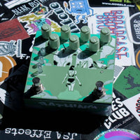 Angled front view of Old Blood Noise Bathing Delay Algae on desk full of stickers