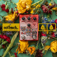 Front view of Old Blood Noise Setback Reverse Pedal laying on flowers on green surface