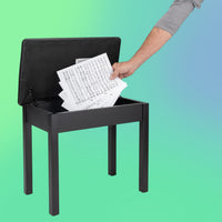 Angled view of On-Stage Flip-Top Keyboard/Piano Bench with arm putting sheet music inside the lid on green and blue background
