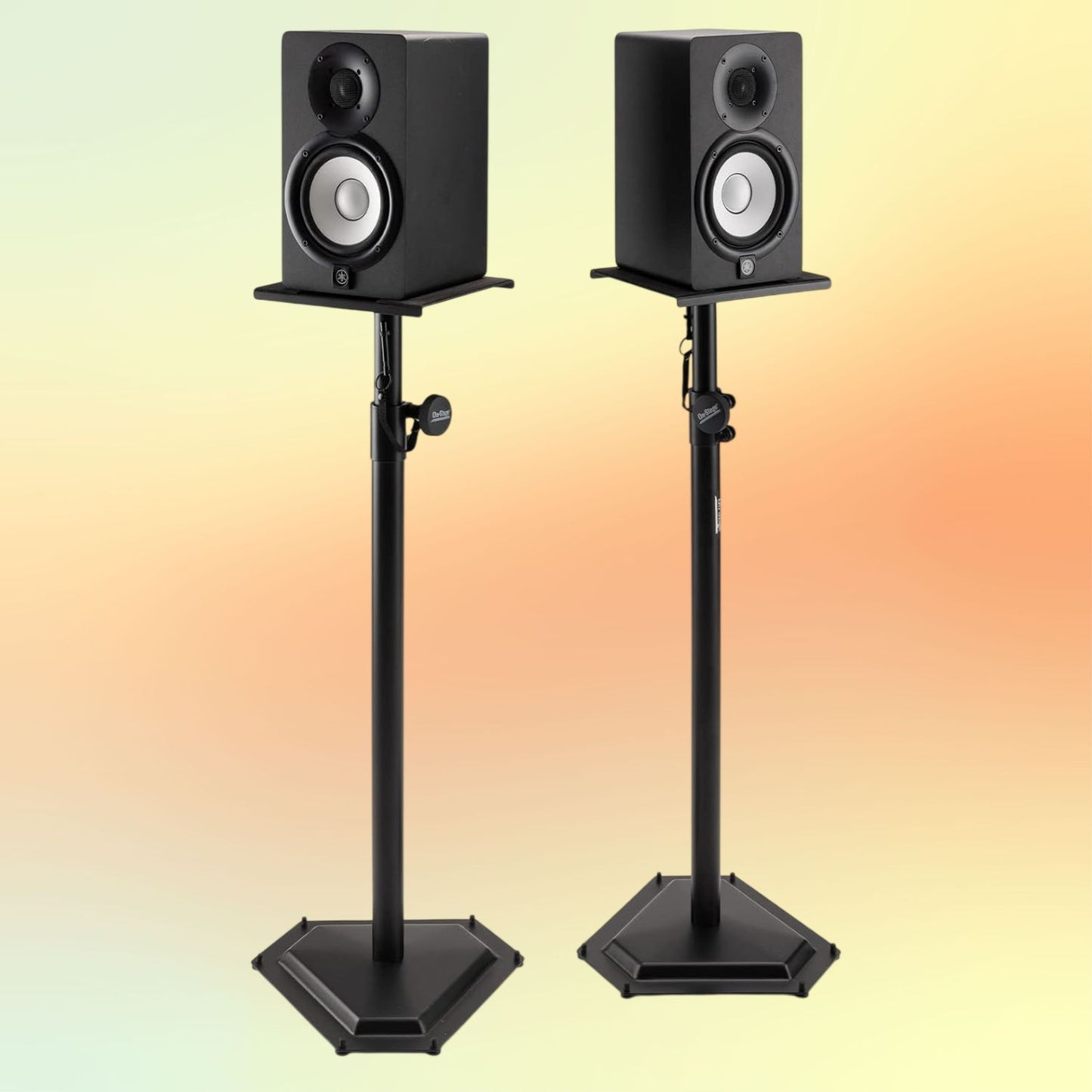 Front view of On-Stage Hex-Base Monitor Stands (Pair) with speakers mounted on yellow and orange background