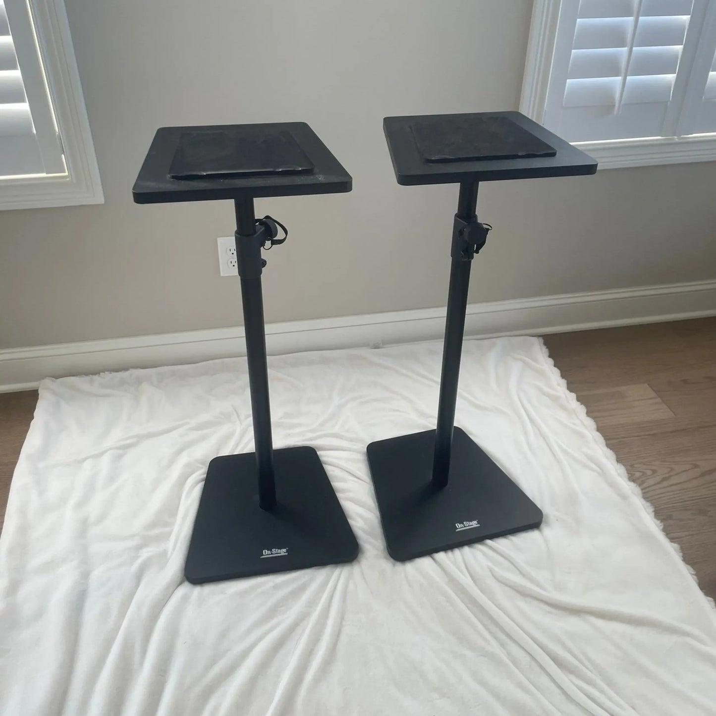 Angled view of On-Stage Wood Studio Monitor Stands (Pair) Black on white rug in room