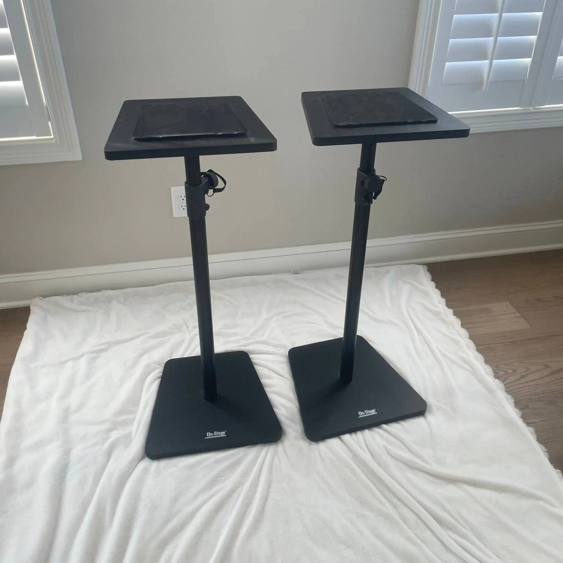 Angled view of On-Stage Wood Studio Monitor Stands (Pair) Black on white rug in room