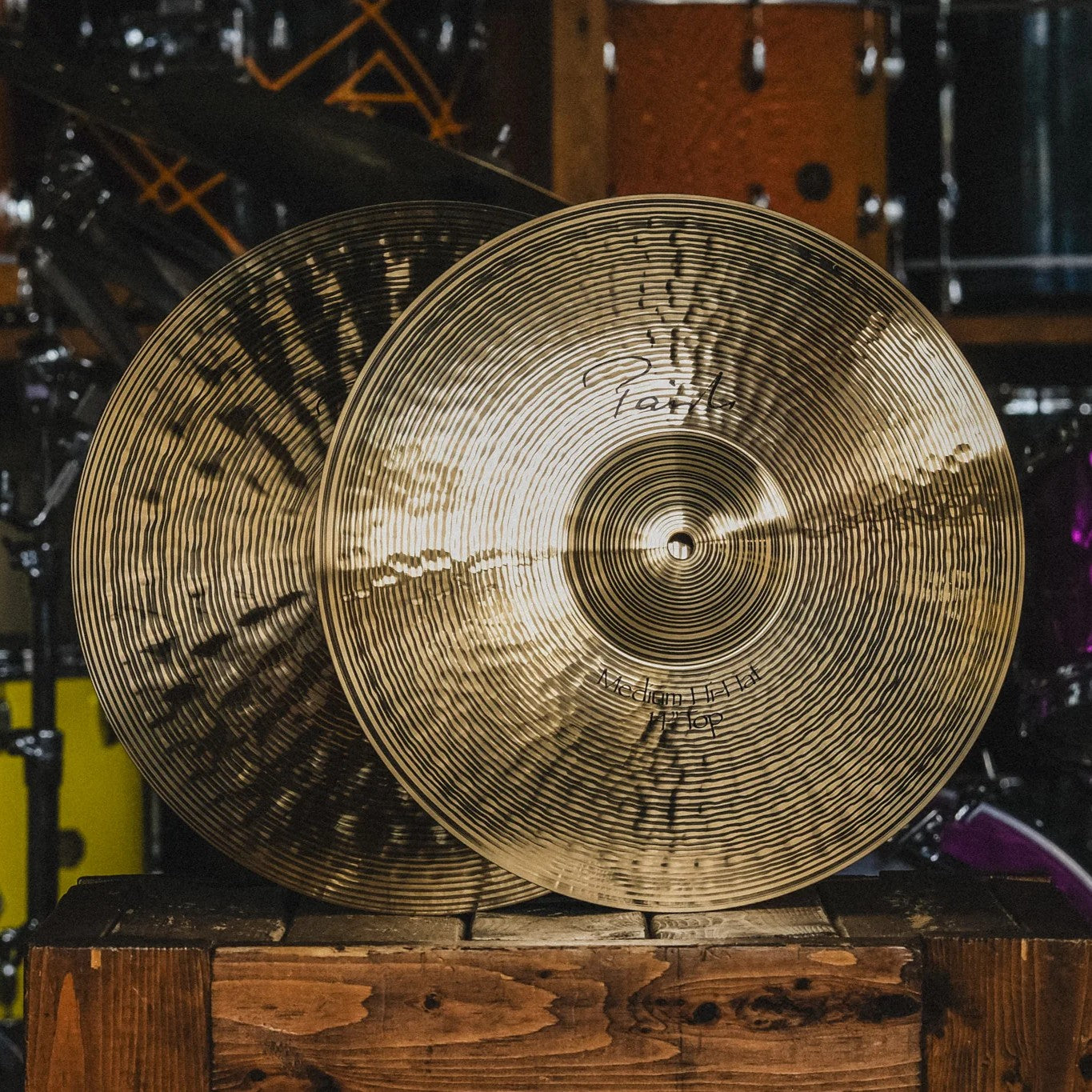 Front view of Paiste 14" Signature Medium Hi-Hats on wooden crate in studio