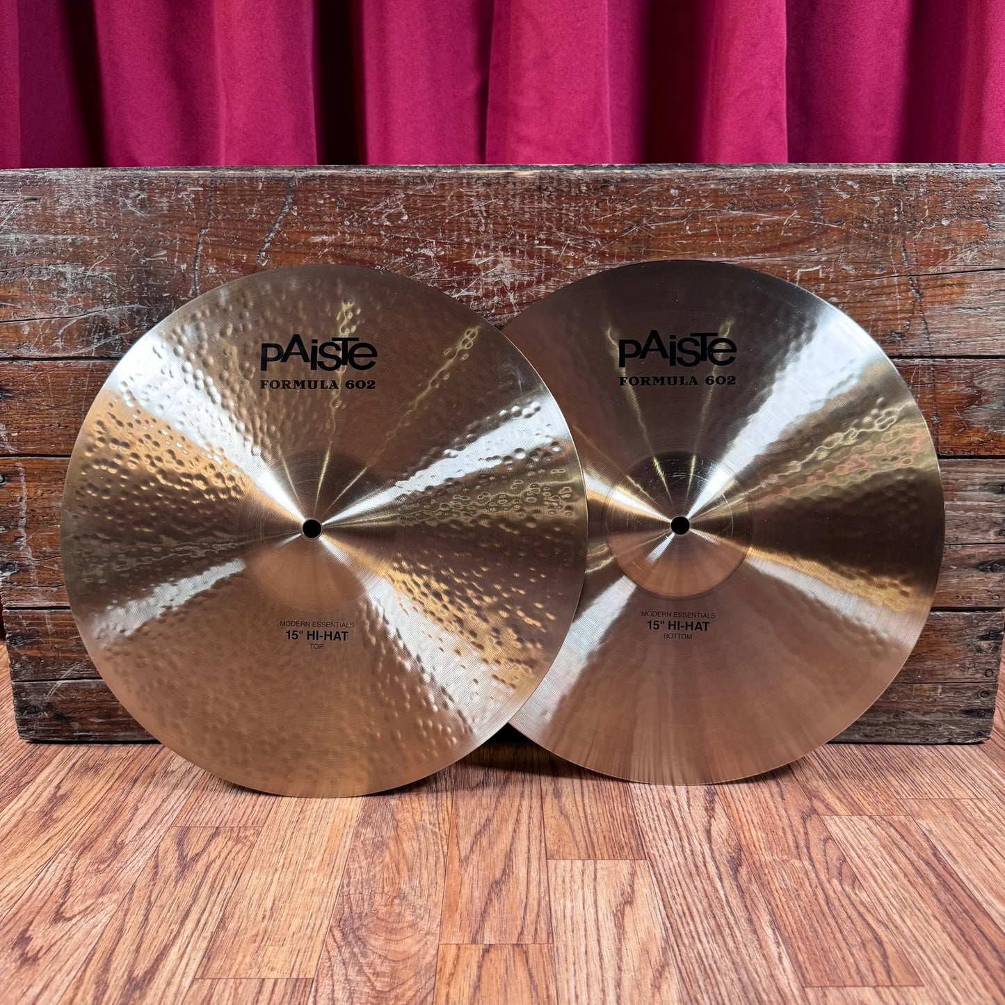 Front view of Paiste 15" Formula 602 Modern Essentials Hi-Hats leaning on wooden crate in studio