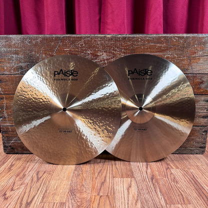 Front view of Paiste 15" Formula 602 Modern Essentials Hi-Hats leaning on wooden crate in studio