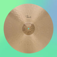 Front view of Paiste 20" Signature Traditionals Light Ride Cymbal on green and blue gradient background