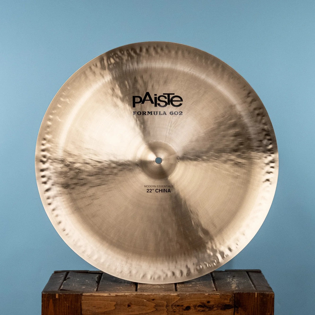 Front view of Paiste 22" Formula 602 Modern Essentials China Cymbal on crate with blue background