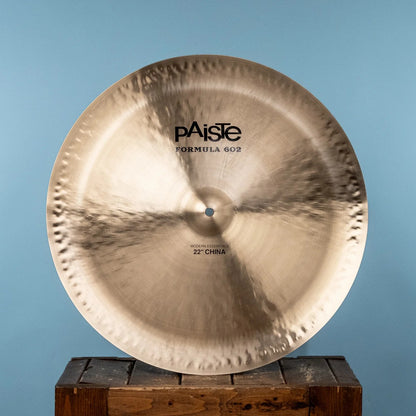 Front view of Paiste 22" Formula 602 Modern Essentials China Cymbal on crate with blue background